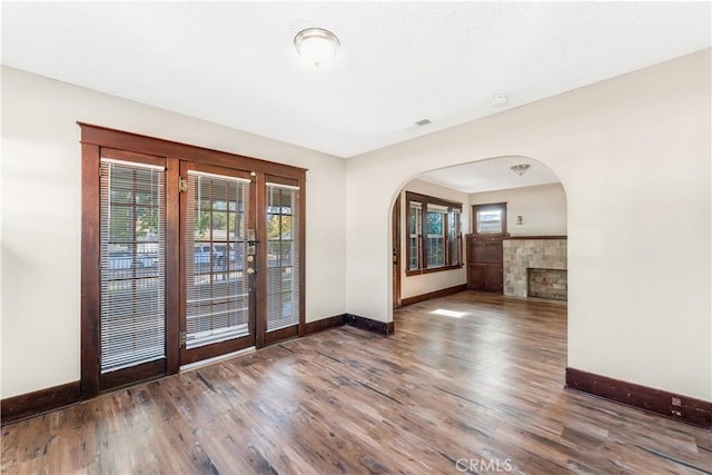 interior space with dark wood-type flooring and a tile fireplace