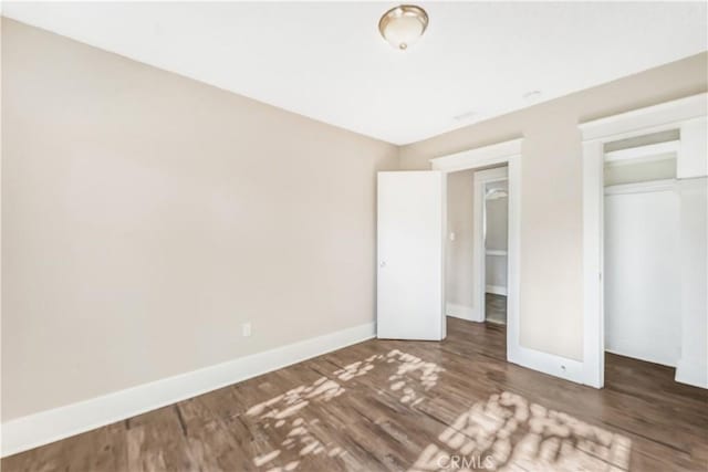 unfurnished bedroom featuring a closet and dark hardwood / wood-style floors