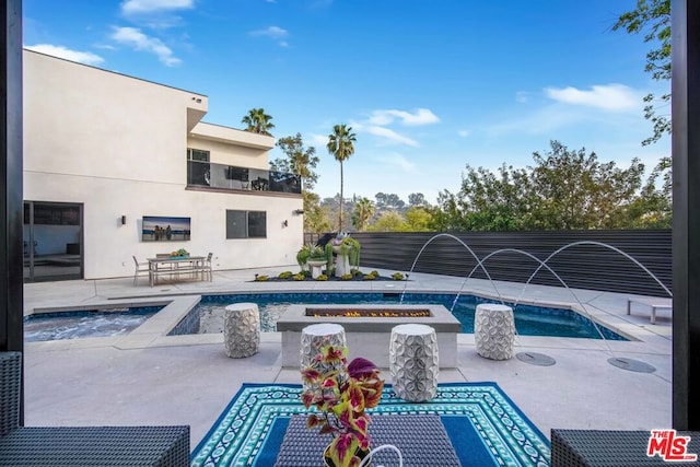 view of pool with pool water feature, a patio, and a hot tub