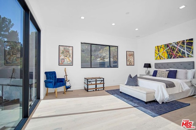 bedroom featuring wood-type flooring and access to outside