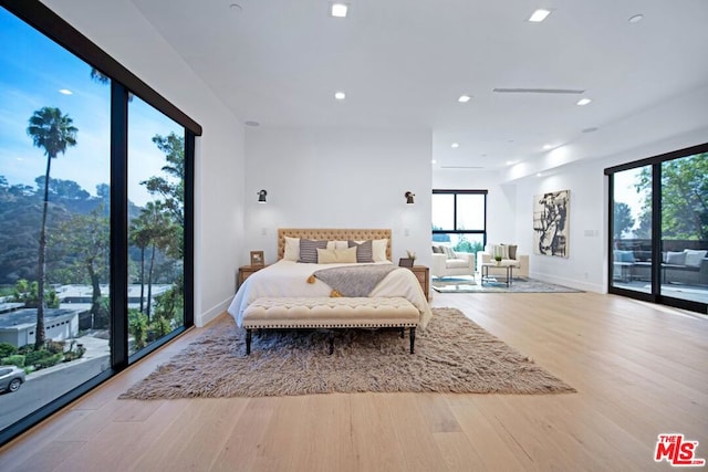 bedroom featuring access to exterior and light hardwood / wood-style flooring