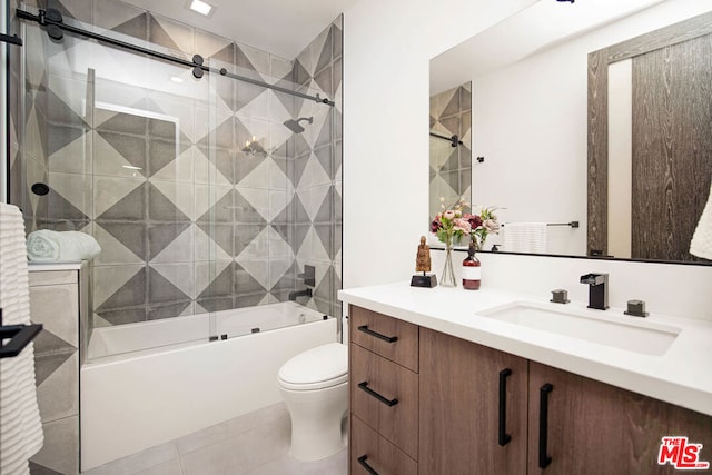 full bathroom with tile patterned floors, vanity, enclosed tub / shower combo, and toilet