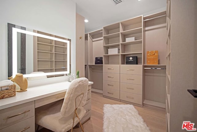 walk in closet with light hardwood / wood-style floors