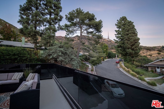 balcony at dusk featuring a mountain view