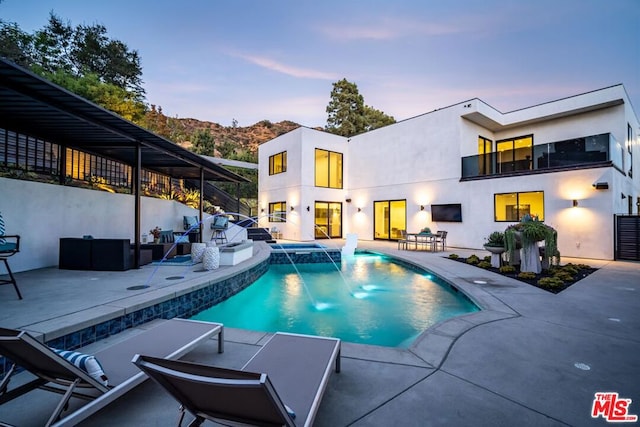 view of swimming pool with an in ground hot tub, outdoor lounge area, pool water feature, and a patio area