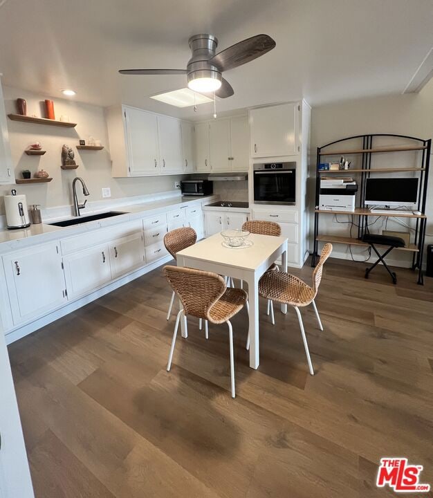 dining area with ceiling fan, sink, and dark wood-type flooring