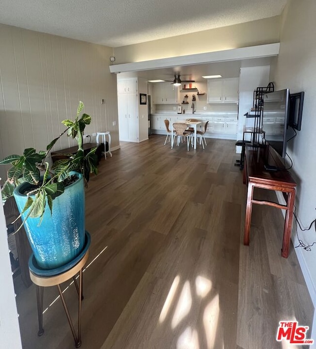 interior space featuring ceiling fan, dark hardwood / wood-style flooring, and a textured ceiling