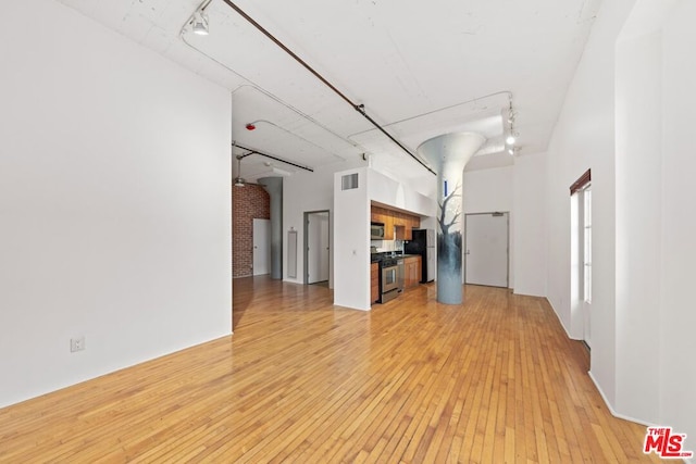 unfurnished living room featuring light hardwood / wood-style floors and rail lighting