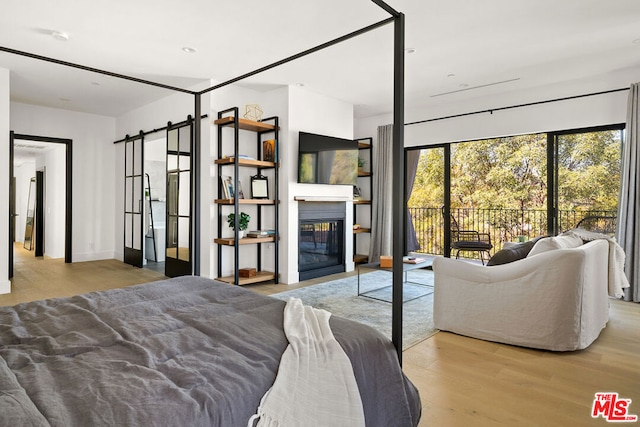 bedroom featuring access to exterior and light wood-type flooring