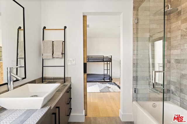 bathroom with vanity, combined bath / shower with glass door, and hardwood / wood-style flooring