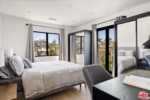 bedroom with access to exterior and wood-type flooring