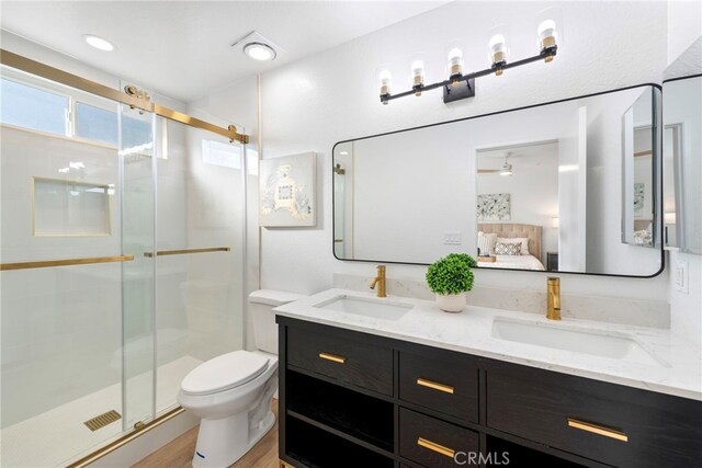 bathroom featuring vanity, a shower with door, ceiling fan, wood-type flooring, and toilet