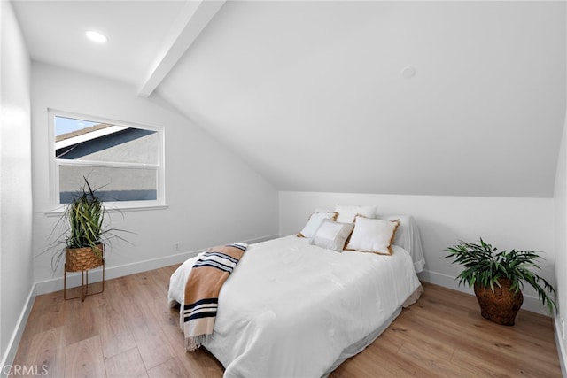 bedroom featuring vaulted ceiling with beams and light wood-type flooring