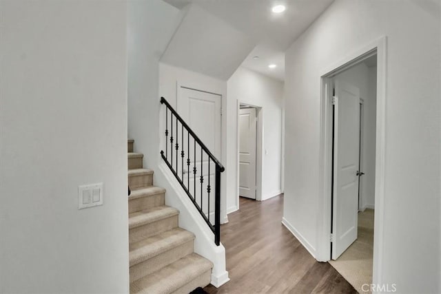 staircase featuring wood-type flooring