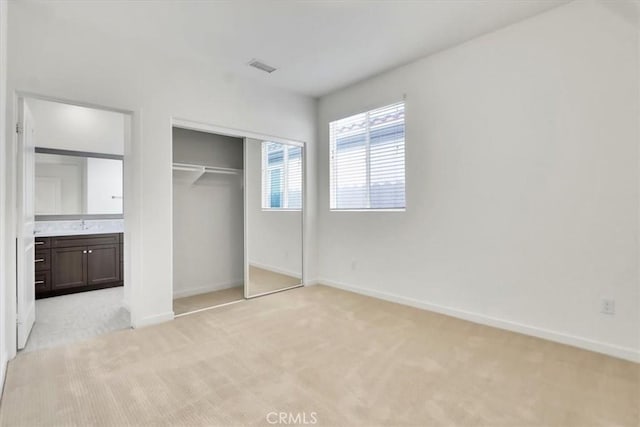 unfurnished bedroom featuring light colored carpet and a closet