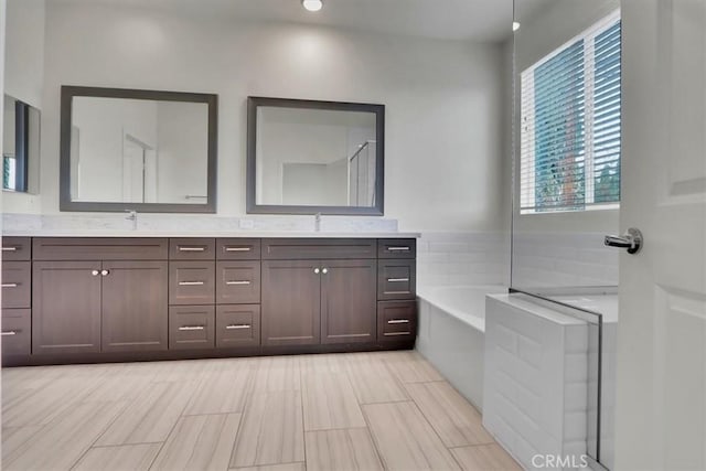 bathroom with vanity and a bath