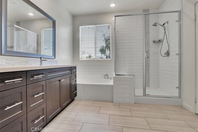 bathroom featuring vanity and shower with separate bathtub