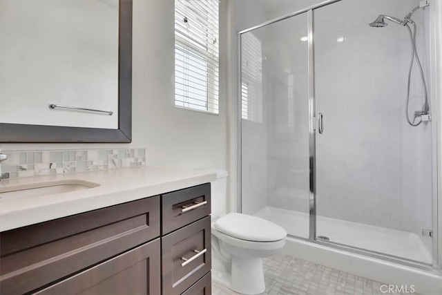 bathroom featuring tasteful backsplash, walk in shower, vanity, tile patterned flooring, and toilet