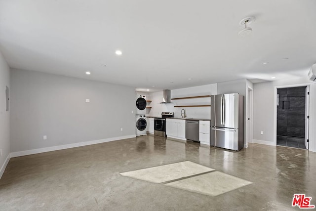 interior space featuring concrete floors, an AC wall unit, stacked washer / dryer, and sink