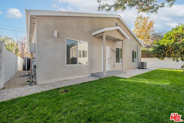 back of property with a yard, a patio, and central AC unit