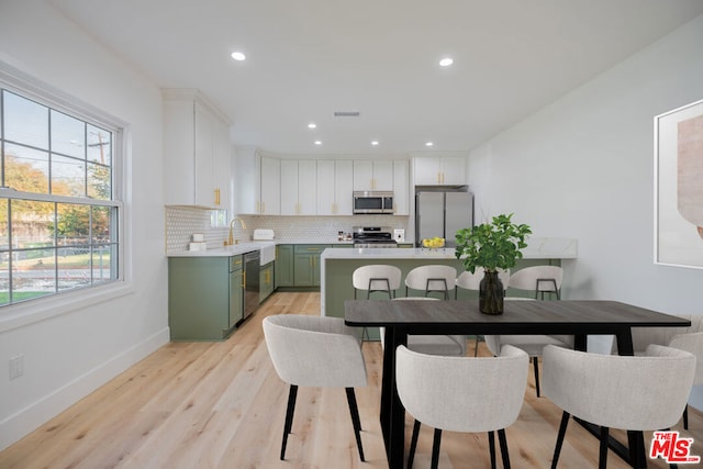 dining area with light hardwood / wood-style flooring and sink