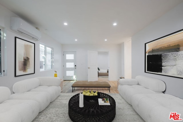 living room featuring light wood-type flooring and an AC wall unit