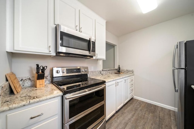 kitchen featuring appliances with stainless steel finishes, dark hardwood / wood-style flooring, light stone countertops, and white cabinets