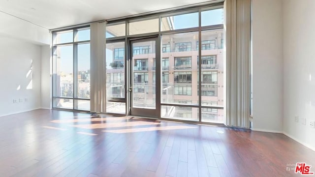 empty room featuring dark hardwood / wood-style floors and floor to ceiling windows