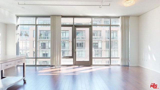 interior space with floor to ceiling windows, wood-type flooring, a wealth of natural light, and french doors