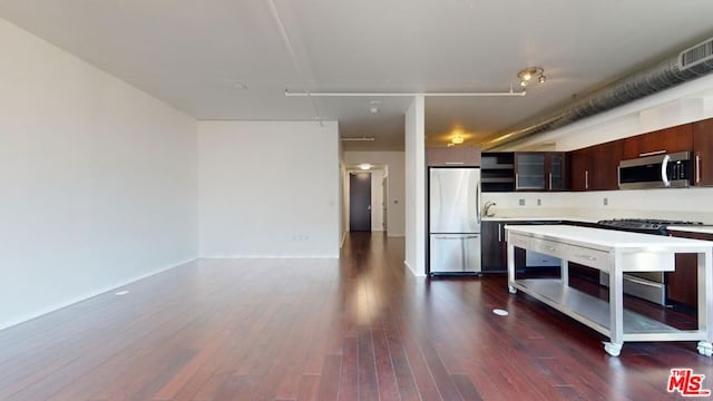 kitchen featuring dark brown cabinetry, sink, dark wood-type flooring, stainless steel appliances, and a kitchen island