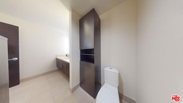 bathroom with tile patterned flooring, vanity, and toilet