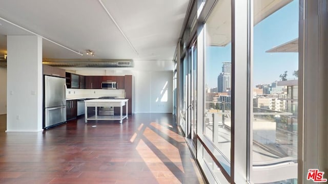 unfurnished living room featuring plenty of natural light and dark hardwood / wood-style flooring