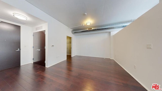 unfurnished room with dark wood-type flooring