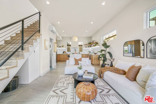 living room with an AC wall unit, a healthy amount of sunlight, and sink