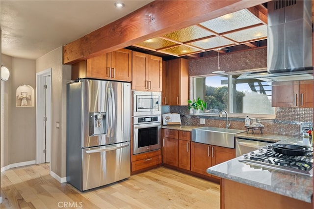 kitchen featuring appliances with stainless steel finishes, decorative light fixtures, sink, and light hardwood / wood-style floors