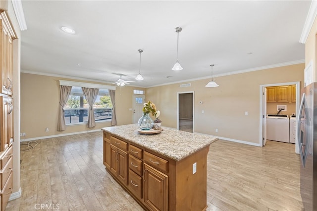 kitchen featuring decorative light fixtures, light hardwood / wood-style floors, stainless steel refrigerator, and a center island