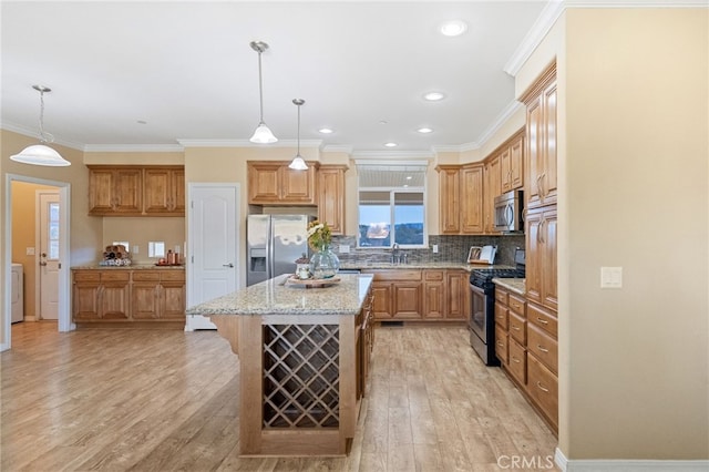 kitchen with light wood-type flooring, stainless steel appliances, pendant lighting, and a center island