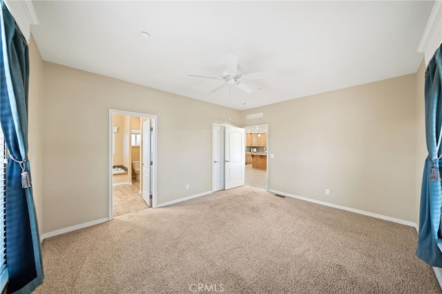 unfurnished bedroom featuring connected bathroom, light colored carpet, and ceiling fan