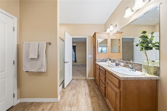 bathroom with hardwood / wood-style flooring, decorative backsplash, and vanity