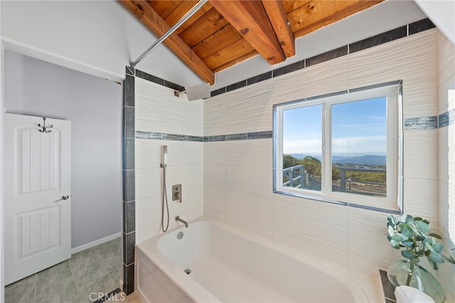 bathroom with tiled shower / bath combo and beamed ceiling