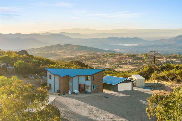 view of front facade with a garage, a mountain view, and an outdoor structure