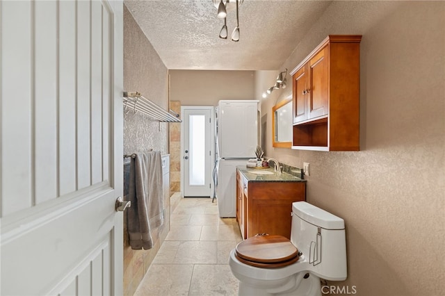 bathroom featuring a textured ceiling, toilet, vanity, and tile patterned flooring