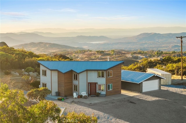 contemporary house with a garage, a mountain view, and an outdoor structure