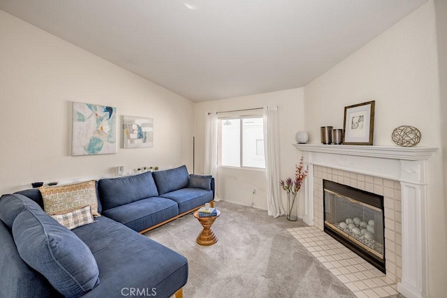 living area with lofted ceiling, carpet, and a tile fireplace