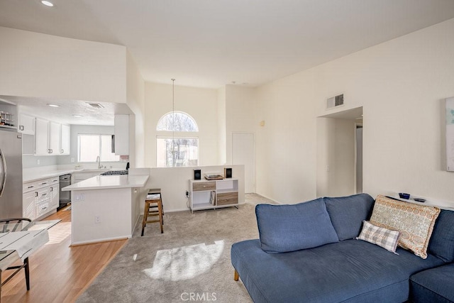 living area featuring light wood-type flooring and visible vents