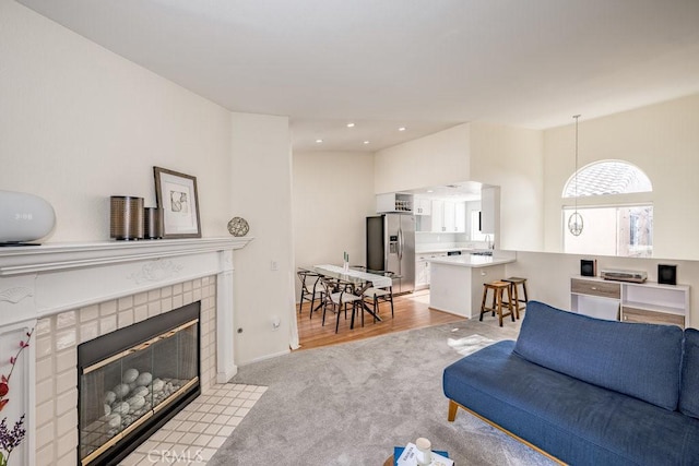 living room with recessed lighting, a fireplace, and light colored carpet