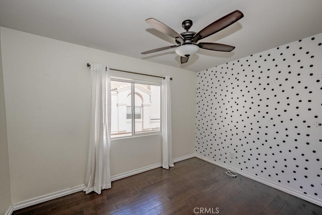 unfurnished room with ceiling fan, baseboards, and dark wood-style flooring