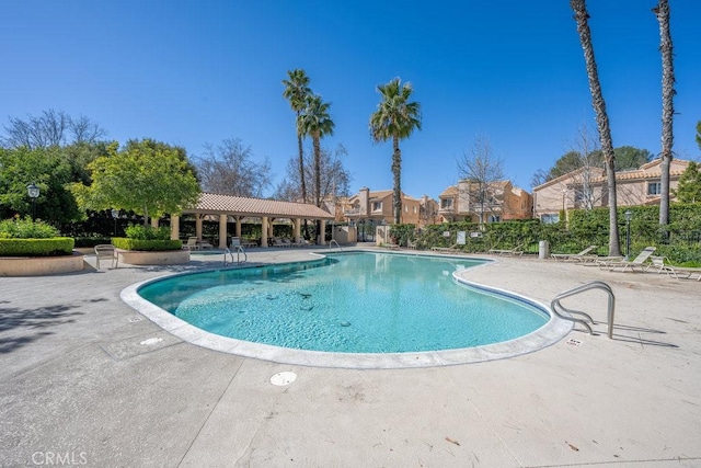 community pool featuring a residential view and a patio