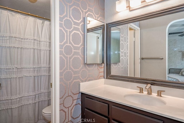 bathroom featuring toilet, a shower with shower curtain, and vanity