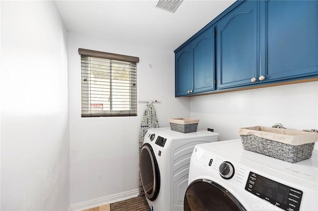 clothes washing area featuring cabinets and washing machine and dryer